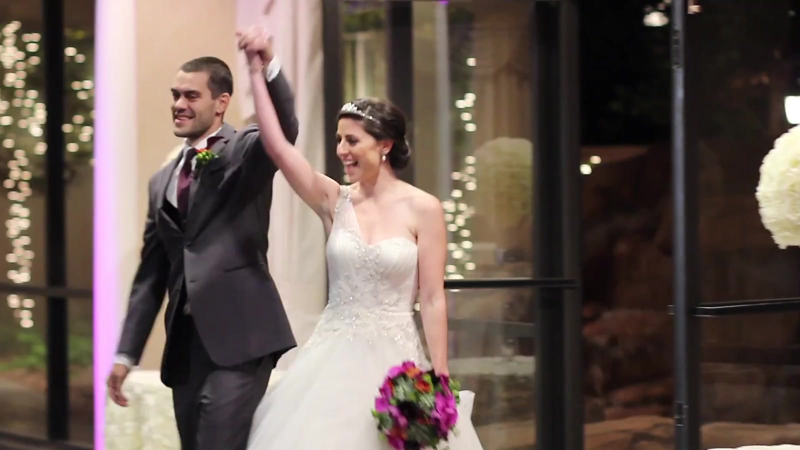The couple entering the celebration with hands raised